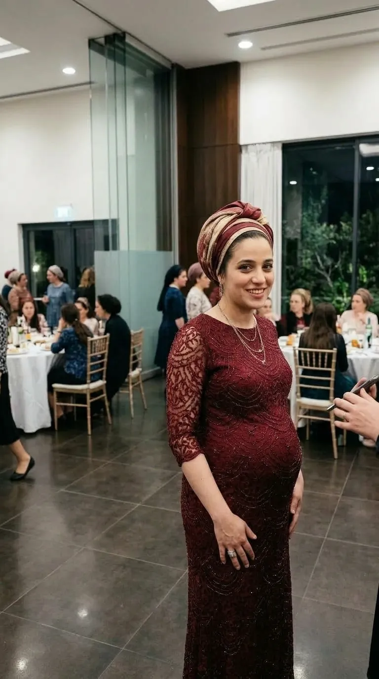 שמלת ערב בגוון בורדו עמוק בגזרת מקסי צמודה, המעוטרת לאורכה בדוגמאות תחרה מסולסלות ושיבוץ חרוזים עדין. השמלה כוללת מחשוף עגול ושרוולי שלושת-רבעי שקופים למחצה העשויים מאותו בד תחרה מעוטר.
