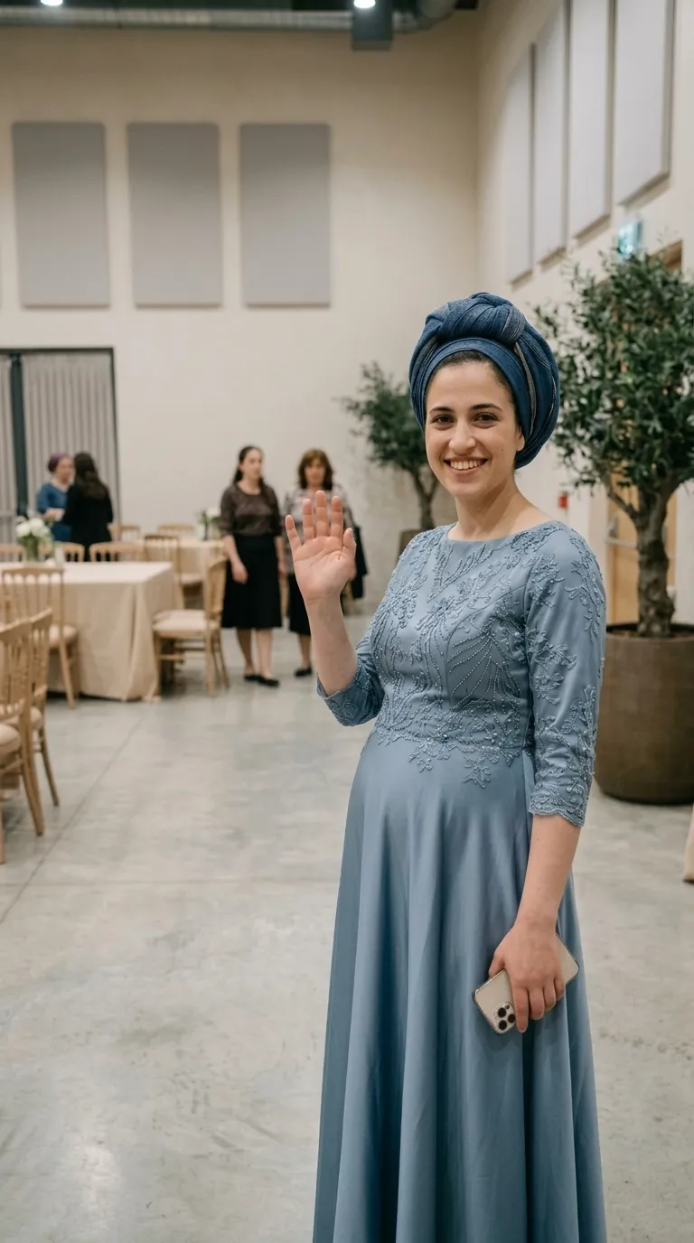 שמלת ערב בגוון כחול מאובק בעלת שרוולי שלושה רבעים ומחשוף עגול וגבוה. חלקו העליון של הבגד והשרוולים מעוטרים ברקמת תחרה עשירה ובשיבוץ חרוזים עדינים בדוגמאות אורגניות, בעוד החצאית חלקה, ארוכה ונשפכת בגזרת A.